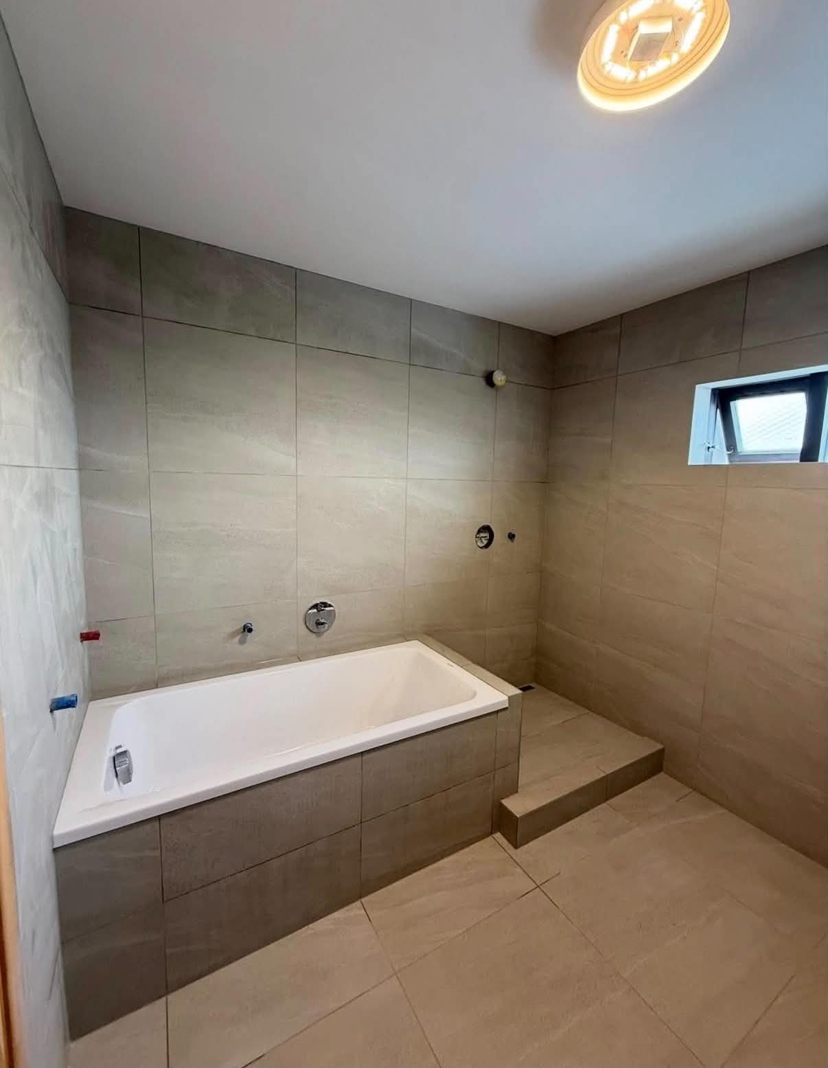 Bathroom after — modern grey-tile finish